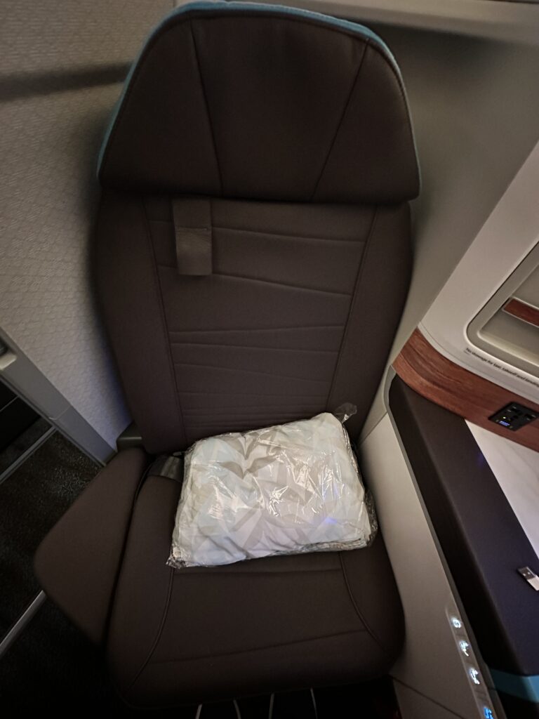 A First Class Experience on Hawaiian Airlines Boeing 787 Dreamliner | Leihōkū Suites | HNL-SFO Hawaii Calling a seat with a pillow on it