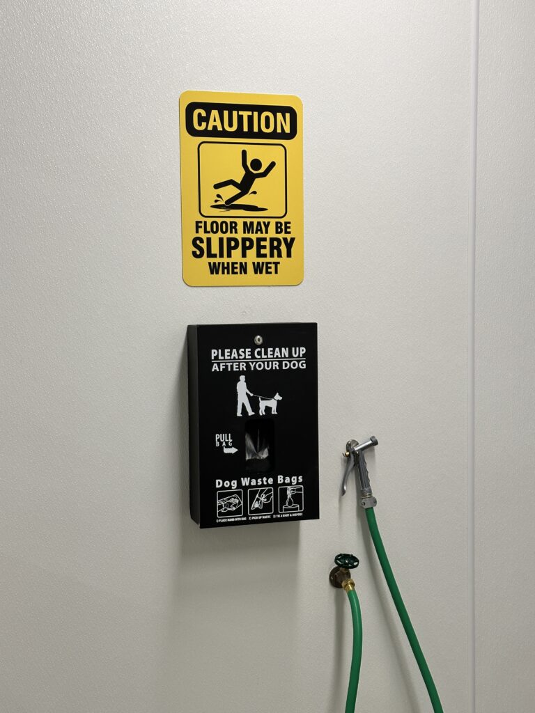 Hilo International Airport Guide (2025) | Big Island Hawai'i (ITO) Hawaii Calling a caution sign and a dog waste bag dispenser