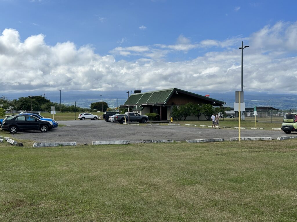Hilo International Airport Guide (2025) | Big Island Hawai'i (ITO) Hawaii Calling a building with a parking lot and cars