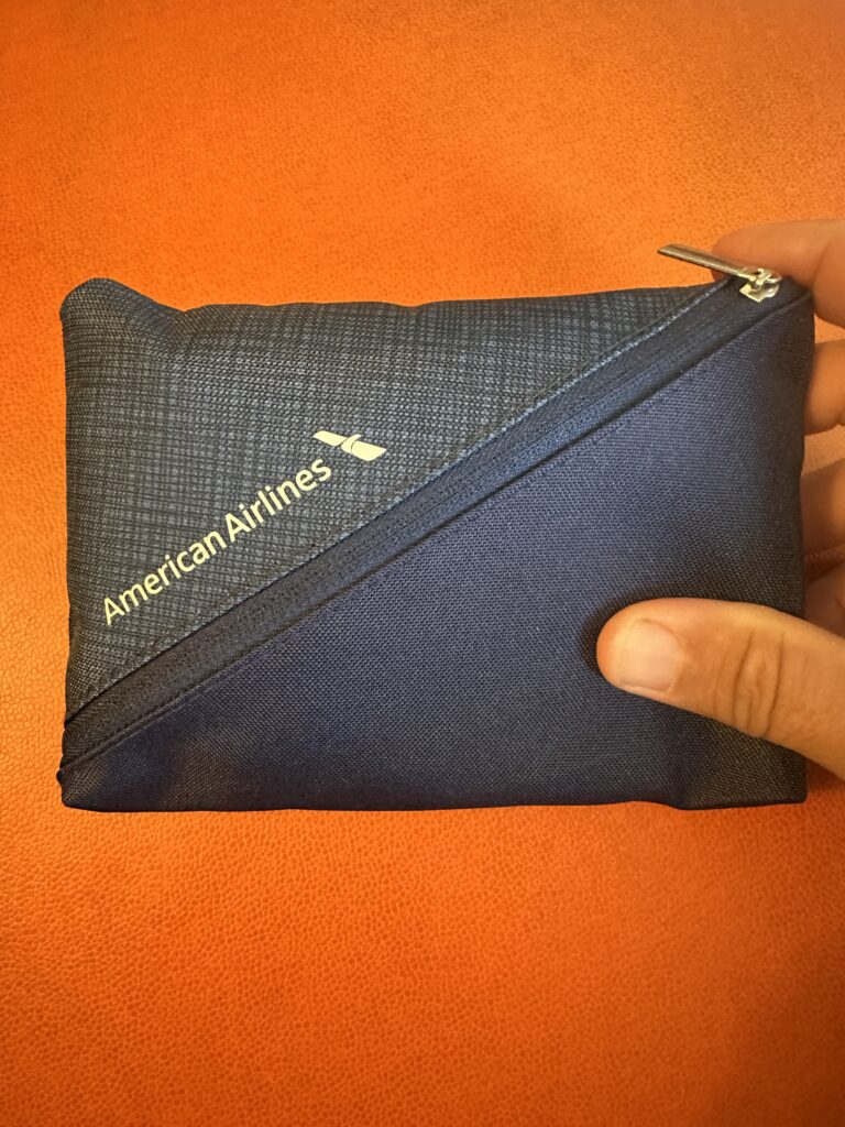 American Airlines Premium Economy Review: Honolulu (HNL) to Phoenix (PHX) on the Boeing 787-8 Hawaii Calling a hand holding a small blue bag