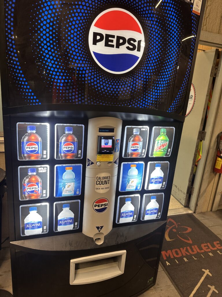 Mokulele Airlines Review: Honolulu (HNL) to Lāna‘i (LNY) | A Scenic Solo Flight Review Hawaii Calling a vending machine with a variety of soda bottles