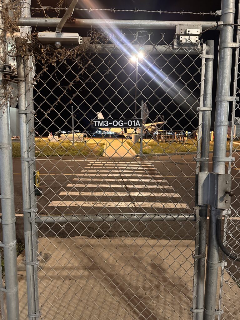 Mokulele Airlines Review: Honolulu (HNL) to Lāna‘i (LNY) | A Scenic Solo Flight Review Hawaii Calling a gate with a sign and a street light