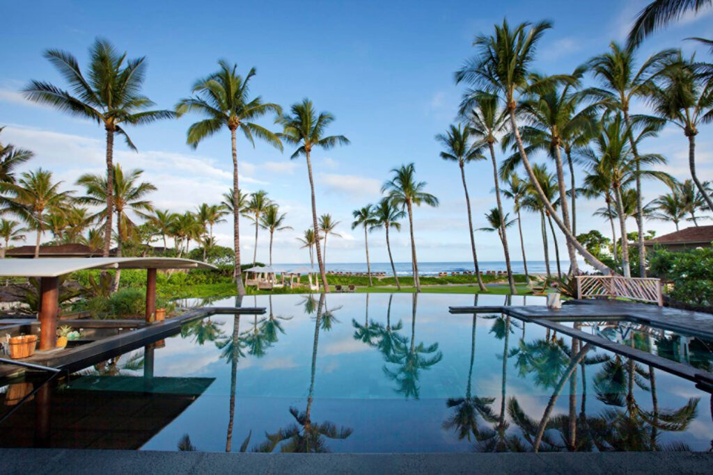 Hawai‘i Hotel Named #1 in the USA for 2025—2 More in the Top 10 Hawaii Calling a pool with palm trees and a beach in the background