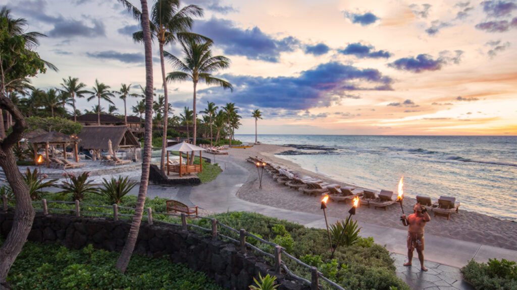 Hawai‘i Hotel Named #1 in the USA for 2025—2 More in the Top 10 Hawaii Calling a beach with palm trees and chairs and a fire on the beach