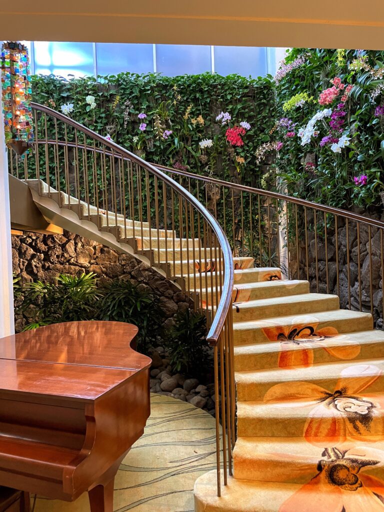 What Hotel Was The New Lilo & Stitch Movie Filmed? Inside the Iconic Kahala Hotel On Oahu Hawaii Calling a staircase with a piano and a wall of flowers