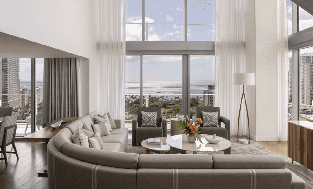 a living room with a large window overlooking the ocean