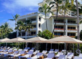 Where to Stay on O’ahu: Comparing Waikīkī, Ko Olina, and the North Shore a pool with umbrellas and lounge chairs in front of a building