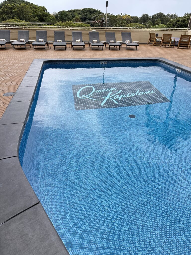 a pool with chairs and a sign