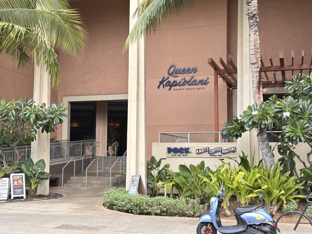 a building with a scooter and palm trees