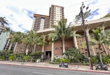 Queen Kapiolani Hotel Review: Retro Charm with Diamond Head Views front of the Queen Kapiolani Hotel in Waikiki with palm trees and a street