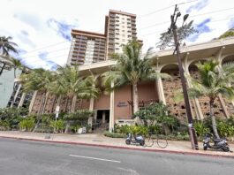 Queen Kapiolani Hotel Review: Retro Charm with Diamond Head Views front of the Queen Kapiolani Hotel in Waikiki with palm trees and a street
