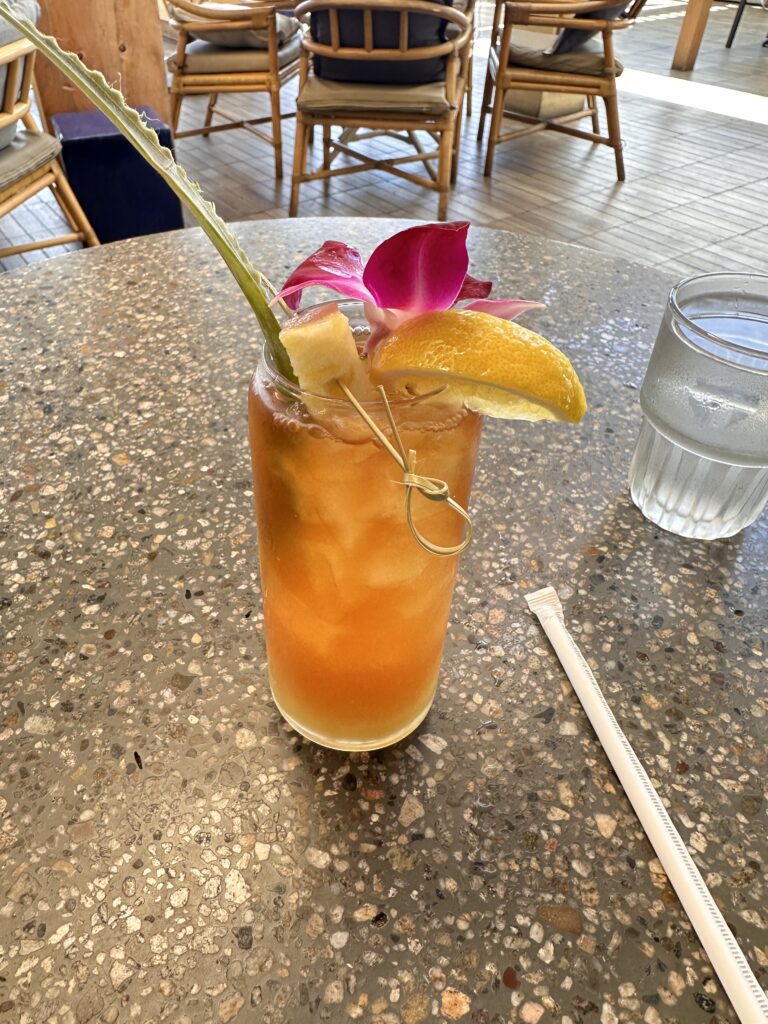 a glass with a drink and a slice of fruit on it