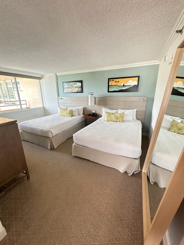 a room with two beds and a mirror