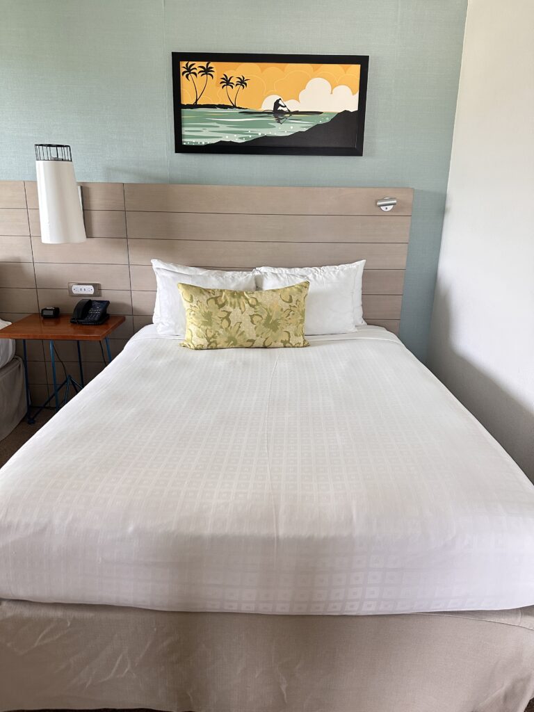 a bed with white sheets and pillows