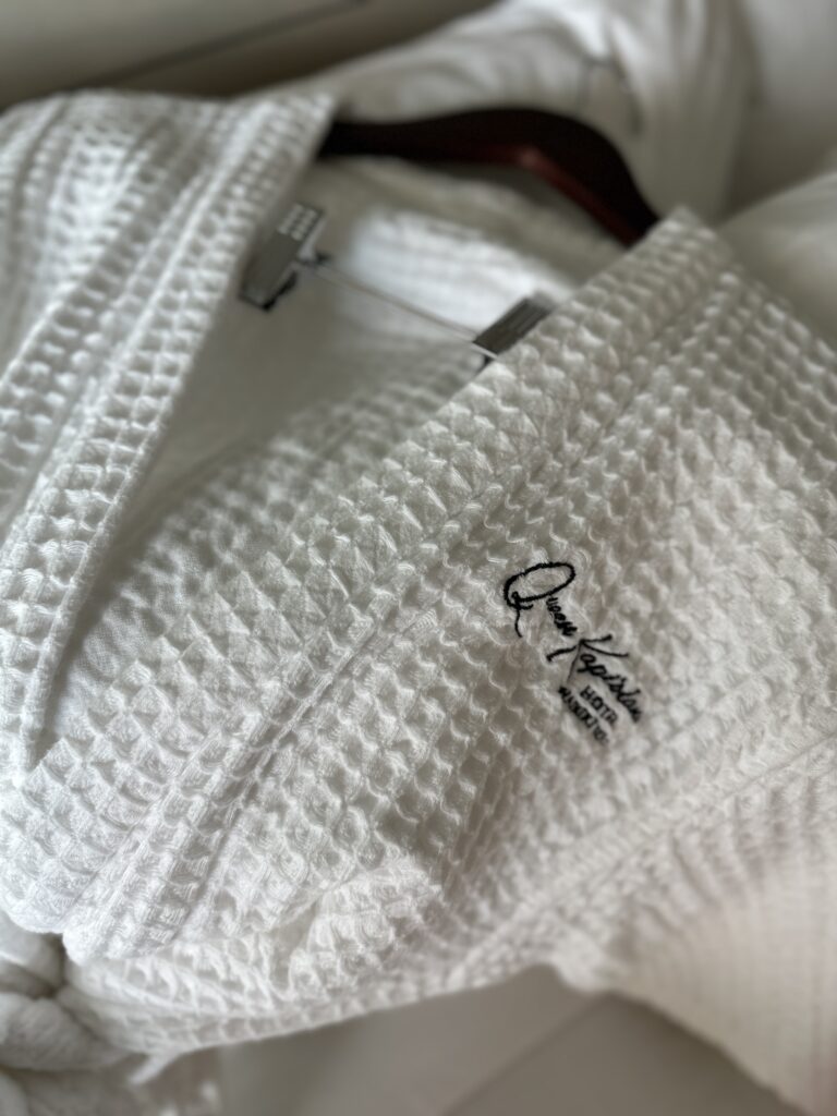 a white robe with a logo on it