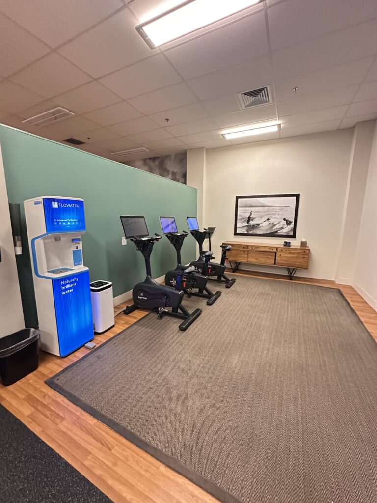 a room with exercise bikes and a green wall