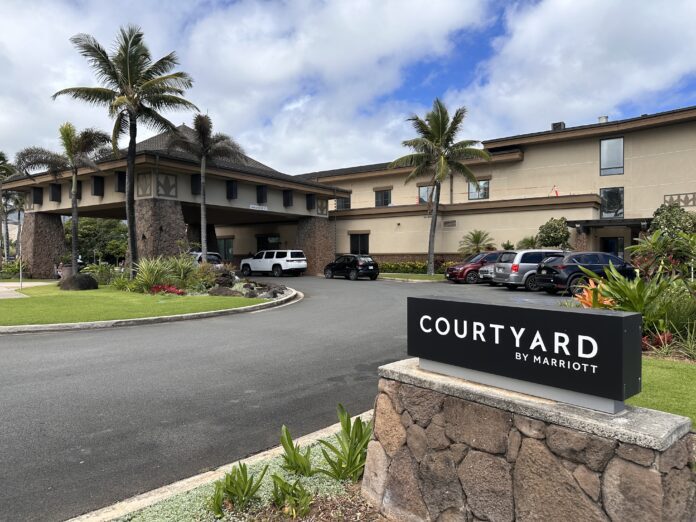 a building with a sign and palm trees