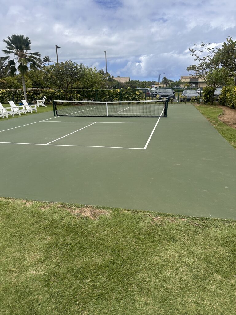 a tennis court with a net and chairs on the side