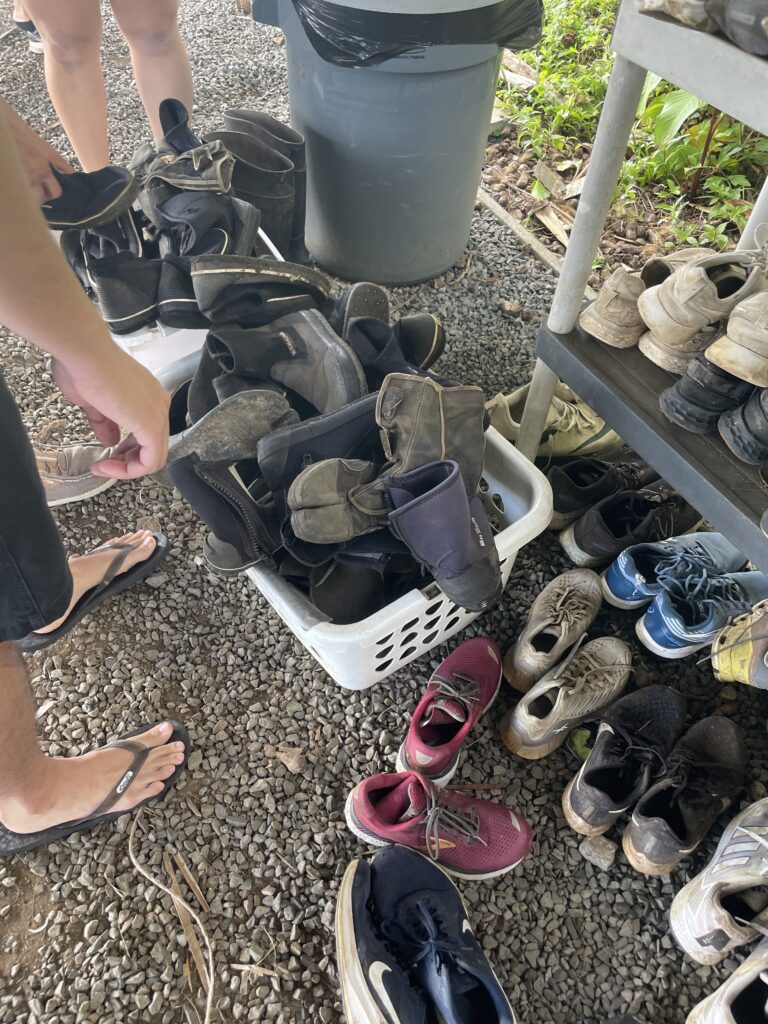 a group of people standing next to a pile of shoes