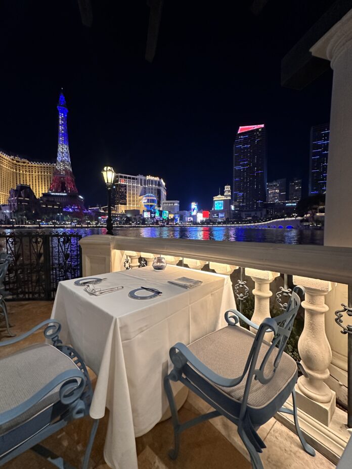 a table and chairs on a balcony overlooking las vegas